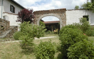 Maison et porche en pierre vus du jardin