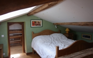 Un coffre en pin en ranger couettes et couvertures à droite et table ancienne complètent les 3 lits de la chambre 4. 