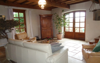 Le salon de ma maison de campagne - Canapé ancien et escalier en chêne menant aux chambres.