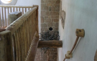 Mezzanine avec échelle de meunier et rampe, sur la gauche ancienne mangeoire en guise de barrière.