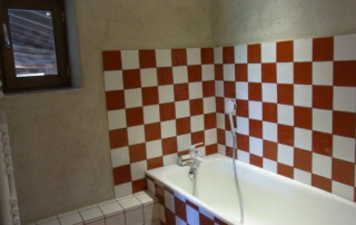 Salle de bains au rez de chaussée avec baignoire et douche.