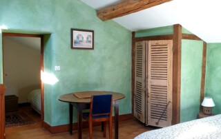 Mezzanine avec grand lit en 160, armoire murale avec ses volets anciens en bois en guise de porte.